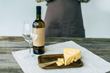 Bottle of wine with empty glass and cheese