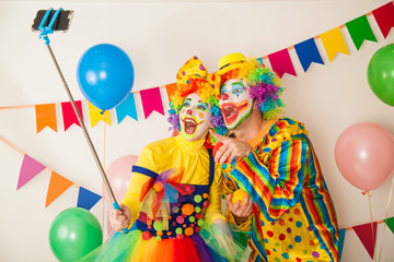 Obraz na płótnie Canvas Two clowns boy and girl on Holiday with a selfie stick. Birthday of the child.