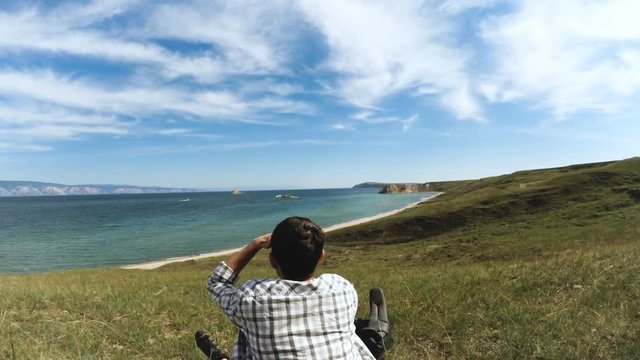 Young brunette tourist resting sitting in shore of Olkhon island, lake Baikal, Siberia, Russia Travel Lifestyle hiking concept summer vacations outdoor