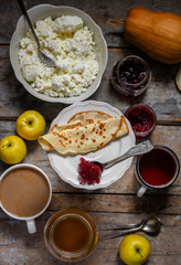 pancakes with jam from rose petals and other sweet additives on the wood surface