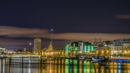 Fototapeta premium Dublin, Irlandia, nocny widok na The Custom House, żaglowiec Jean Johnston, most Sean O'Casey na rzece Liffey i The Spire.