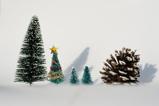 Artificial Christmas trees and pinecorn with shadow on white background using for Christmas decoration concept.