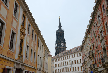 Fototapeta na wymiar Dreikoenigskirhe Church tower above buildings on Rahnitzgasse Street, Dresden, Germany.