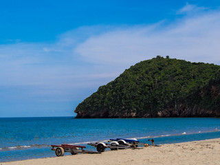 The boats on the beach on the sea with mountain and blue sky background