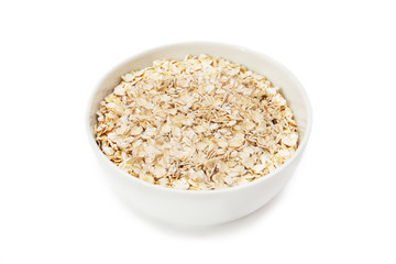 oat flakes in a white bowl on a white background