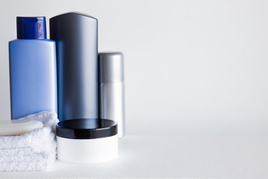 Different beauty toiletries on the gray background. Cares about a men's hair and body skin. Mock up for seasonal offers as advertising or other ideas. Empty place for a text. 