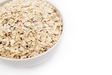 oat flakes in a white bowl on a white background