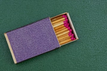 синий коробок с спичками на зелёной поверхности