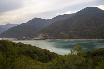 Красивый вид на живописное озеро между холмами, водоем, облачная погода, отдых на природе