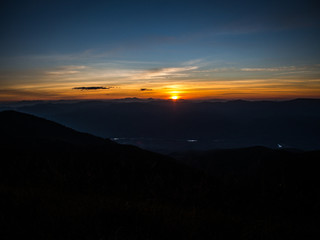 The sun is setting in the far away behind the mountain range in Chiangmai, Thailand.