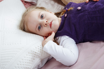 Cute little girl with a plaits on a white background close-up