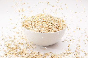 oat flakes in a white bowl on a white background