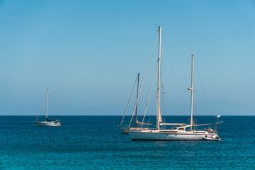 Fototapeta premium Three anchored yachts in the blue sea