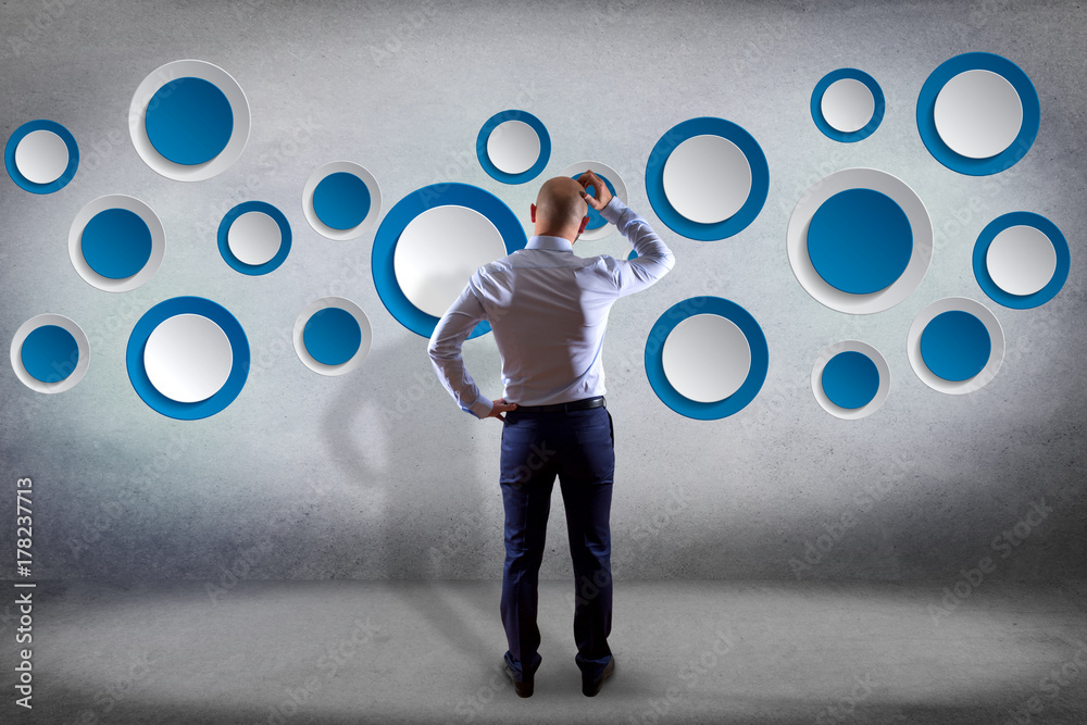 Poster businessman in front of a wall with empty app interface made of blue button displayed on a interface