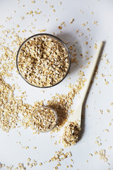 oat flakes in a transparent bowls with spoon on a white background