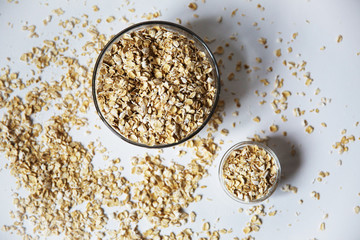 oat flakes in a transparent bowls on a white background