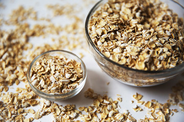 oat flakes in a transparent bowls on a white background