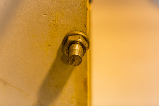 Large bolt thread and metal nut in the wall