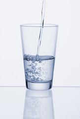 Glas mit sauberem,Trinkwasser auf weissem Untergrund