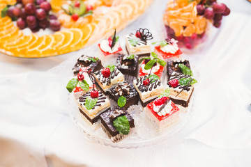 Obraz premium Delicious and tasty dessert table with cupcakes shots at reception closeup