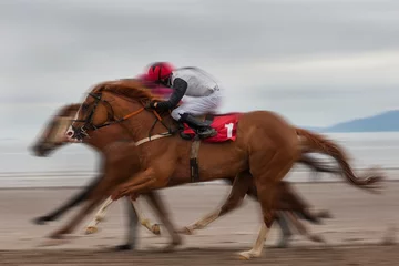 Crédence de cuisine en verre imprimé Léquitation Speeding race horses and jockeys running on the beach, motion blur effect