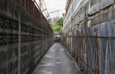 concrete gray wall and galvanized iron in desolate alleyway