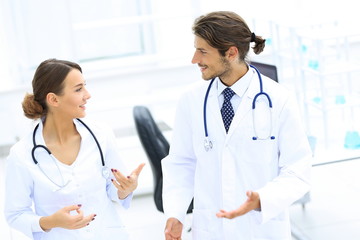 Two Doctors Having Meeting In Hospital Reception Area