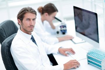 Young male technician working on computer in laboratory