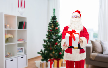 Fototapeta premium santa claus with christmas gift at home