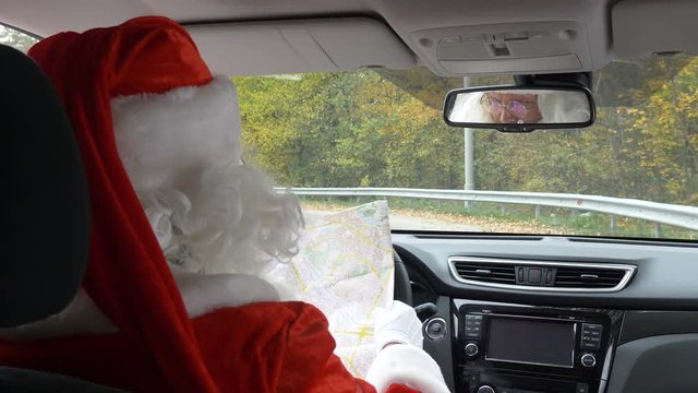 Santa Claus lost his way and is looking at the map back view 50 fps