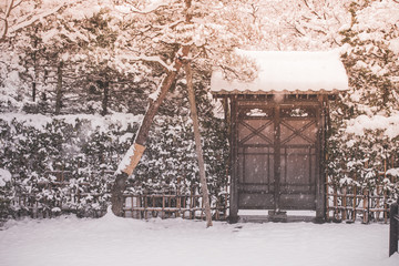 Beautiful winter seasonal view old wooden door with roof covered with white snow in vintage style.
