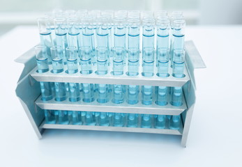 Blue water in a transparent test-tube on light background