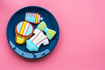Child birthday celebration with gingerbread cookies on plate on pink colorful background top view space for text