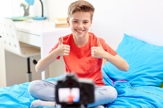 happy boy with camera recording video at home