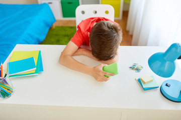 tired or sad student boy with smartphone at home