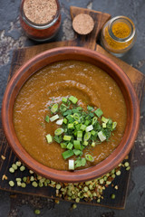 Cream-soup with peas and curry topped with fresh greens, view from above, studio shot