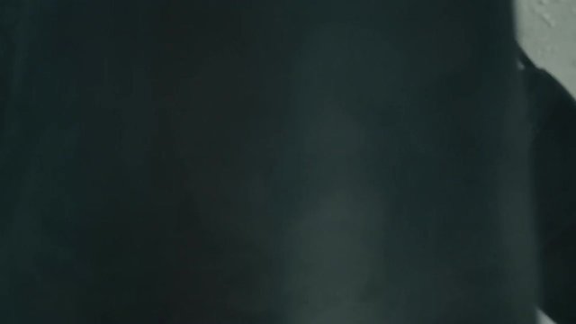 The athlete trains before the fight. A boxer punches the heavy bag. Black background