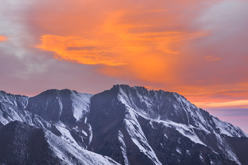 Obraz premium pomarańczowy zachód słońca nad górskimi szczytami