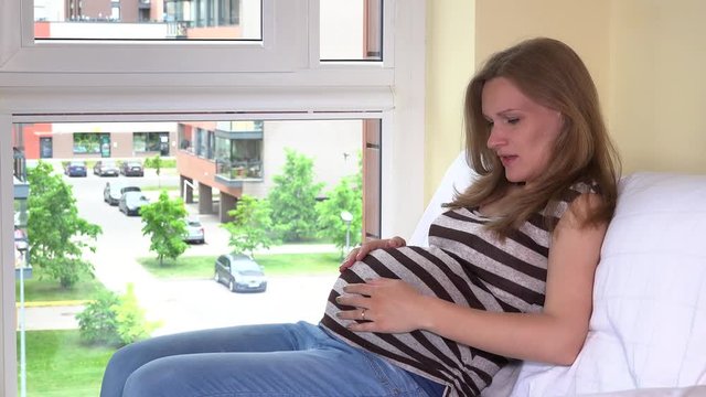 Playful pregnant woman talk and play with unborn baby inside her belly stomach