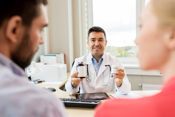 Fototapeta premium doctor showing medicine to family couple at clinic