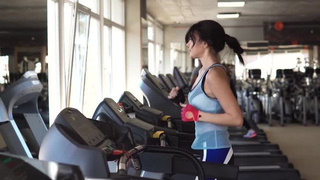 young sporty girl running on the treadmill at the gym