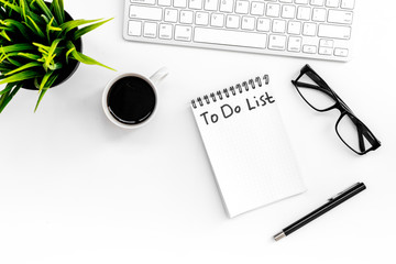 To do list for businessman in notebook on office table. White background top view copyspace