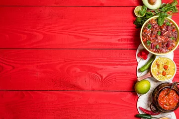  Vegetarian Mexican food concept: refried black and red beans. guacamole, salsa, chili, tortilla chips and fresh ingredients over vintage red rustic wooden background. Top view, flat lay © jarvna