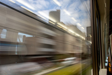 Fototapeta premium a view out from the window of a train. The industrial area is running behind the windows of a traveling train