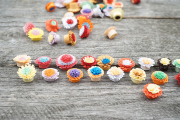 Small, colorful paper flowers made with quilling technique 
