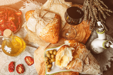 A glass of dry red wine and Italian Focaccia bread with cheese and olive oil and sun dried tomatoes. Selective focus.