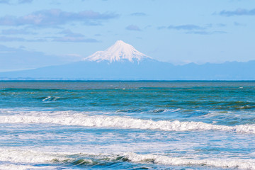 View on Mount Taranaki across Tasman sea at sunny day. Taranaki region, New Zealand.