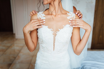 bridesmaids help to wear a wedding dress