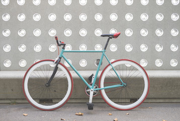 A City bicycle fixed gear on a green and white wall