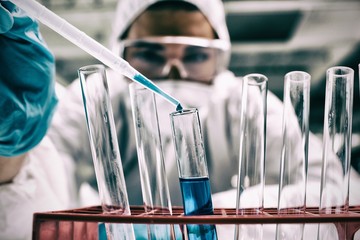 Close-up of science student dropping blue liquid in test tube © vectorfusionart